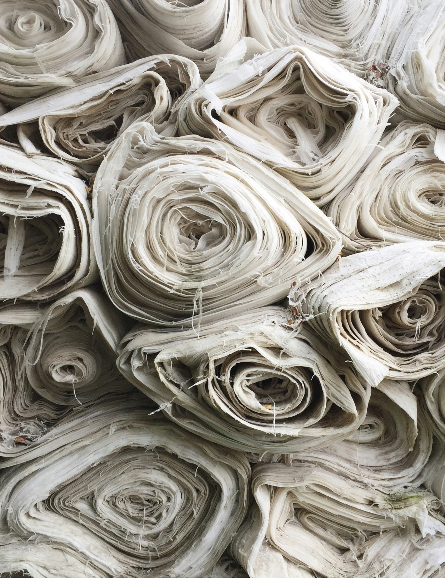 Rolls of natural undyed cotton fabric stacked in the Prospera warehouse